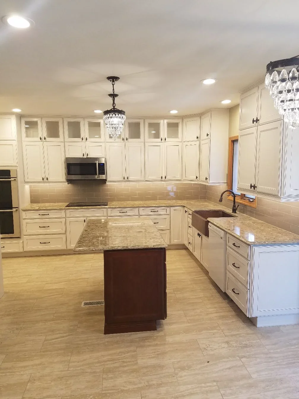 Cream shaker cabinets, granite counters, subway tile backsplash, dark wood island, stainless steel appliances