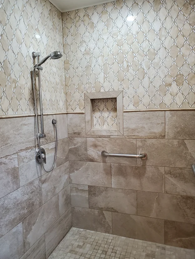 Walk-in shower with travertine tile, diamond pattern accent, rainfall showerhead, and chrome grab bars